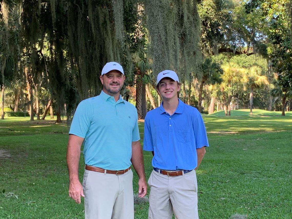 Brian McCarter who saved his neighbor last year from an alligator attack in a lagoon behind her home on Callawassie Island stands beside his son, Will McCarter, on a golf course.