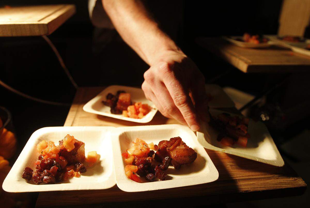 Scott Bodkin, Executive sous chef at HH Prime, dishes up some pineapple glazed ham with candied bacon with a pineapple cherry chutney during the 25th Annual Taste of the Season at Hilton Head Marriott Resort & Spa on Dec. 5, 2014.
