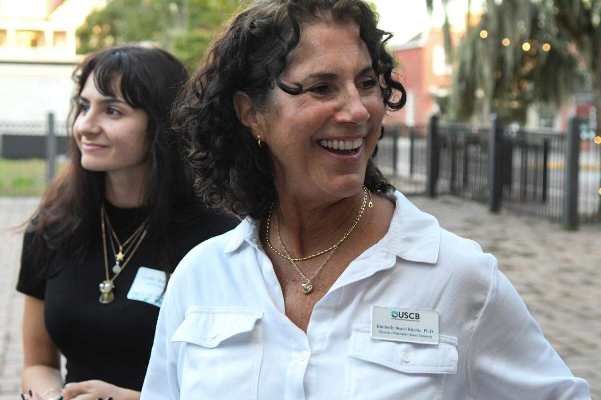 USCB professor Kimberly Ritchie, center, speaks with friends and colleagues before the start of USCB’s “Return to Pritchards Island” presentation held at Tabby Place on Wednesday, Nov. 13, 2024 in Beaufort. Ritchie is an associate professor of genetics and prokaryotic cell biology and is the director of Pritchards Island research.