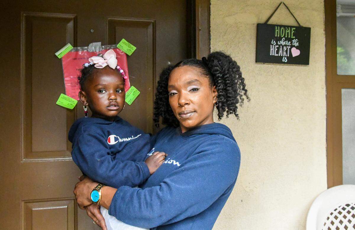 Briana Cohen holds her daughter Bri’Riana Chaplin, 2, for a portrait at the front door of their fire-damaged Sandalwood Terrace apartment on Thursday, Oct. 22, 2020 on Hilton Head Island. Cohen and her daughter have been staying with a relative in Beaufort after wiring in the three-bedroom apartment caused a fire on Sept. 11, 2020. It is in the process of being repaired.