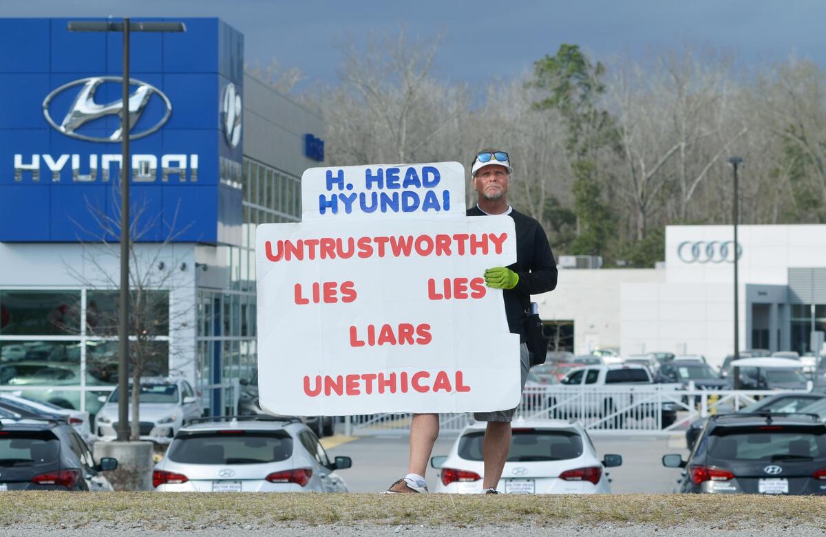 Greg Sanford Hackney stands, on Feb. 7, with his protest sign on the shoulder of U.S. 278 in Jasper County outside the Hilton Head Hyundai dealership. On Nov. 13, a judge ruled his actions were defamatory and not protected by the First Amendment, and ordered a stop to his protest.
