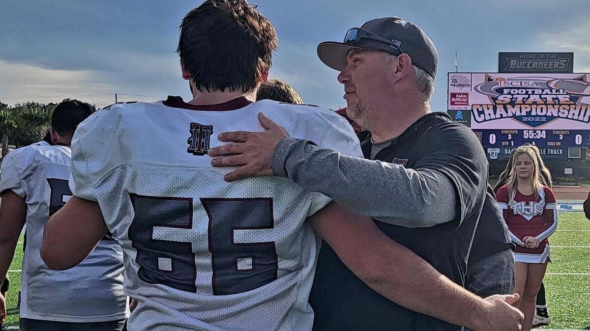 Thomas Heyward coach Nic Shuford, right, hugs one of his players after the SCISA Class A football championship game on Nov. 19, 2022.