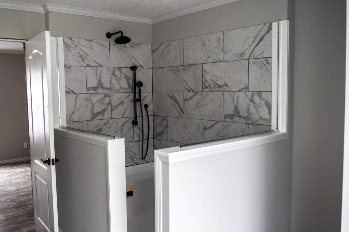 The primary bath has a walk in spa, a vanity for two and a tub in the “Big Easy” manufactured home sold by Palmetto Homes of Beaufort.