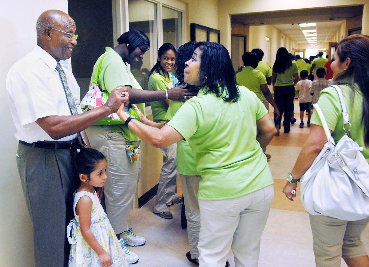 Rickie Johnson, a Head Start teacher at the Children’s Center, greets founder Isaac Wilborn during the open house for a new building in this file photo from 2010.