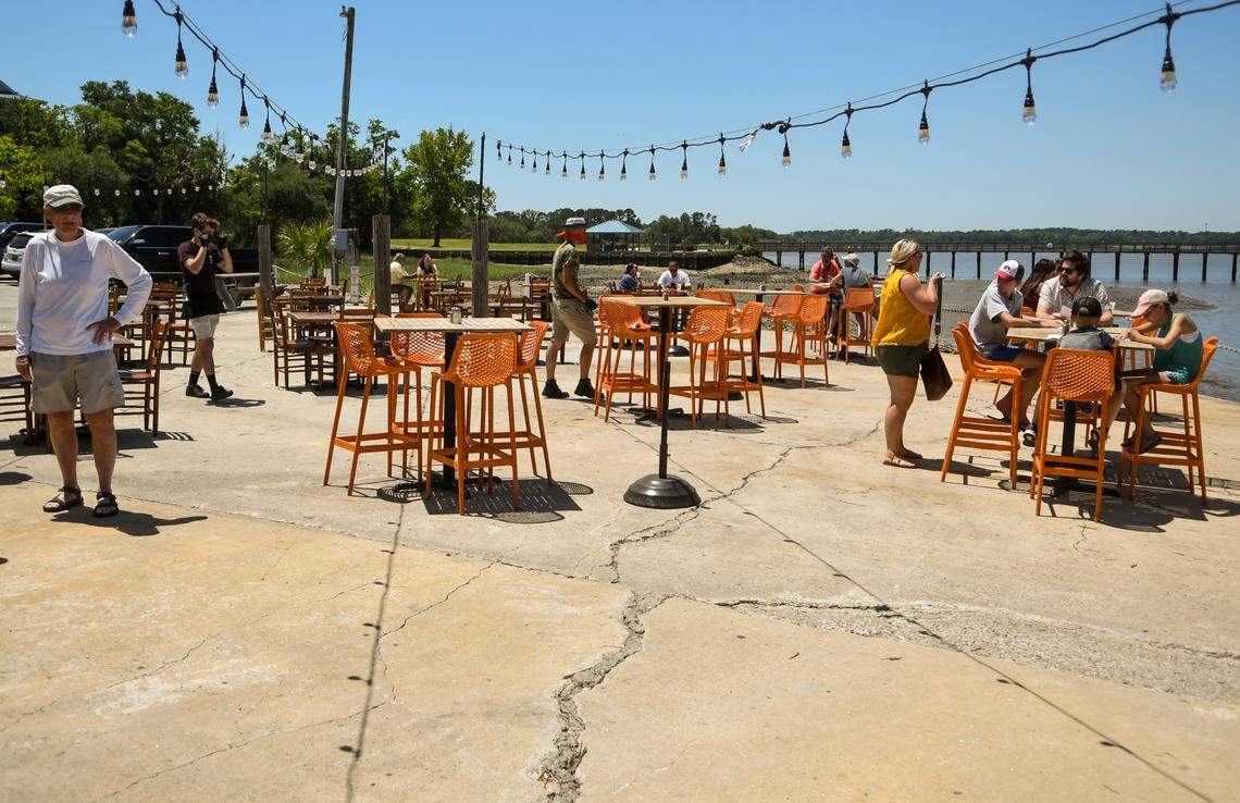 Tables spaced about 10 feet from each other sit on the patio of Hudson’s Seafood House on the Dock on Monday, May 4, 2020. “We have all of this beautiful 70 degree weather and then we have this (90 degree day) when we’re trying to get up and running.” owner Andrew Carmine said from the phone as he was buying more umbrellas for his tables. Monday marked the first day that restaurants could serve customers in outdoor spaces if certain precautions were met to help stave off the spread of the coronavirus.