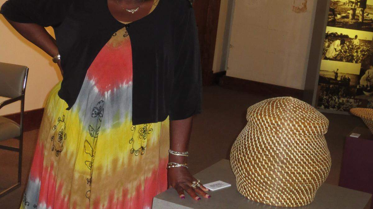 Jery Taylor with one of her bulrush-sweetgrass baskets on display at the York W. Bailey Museum at Penn Center on St. Helena Island.