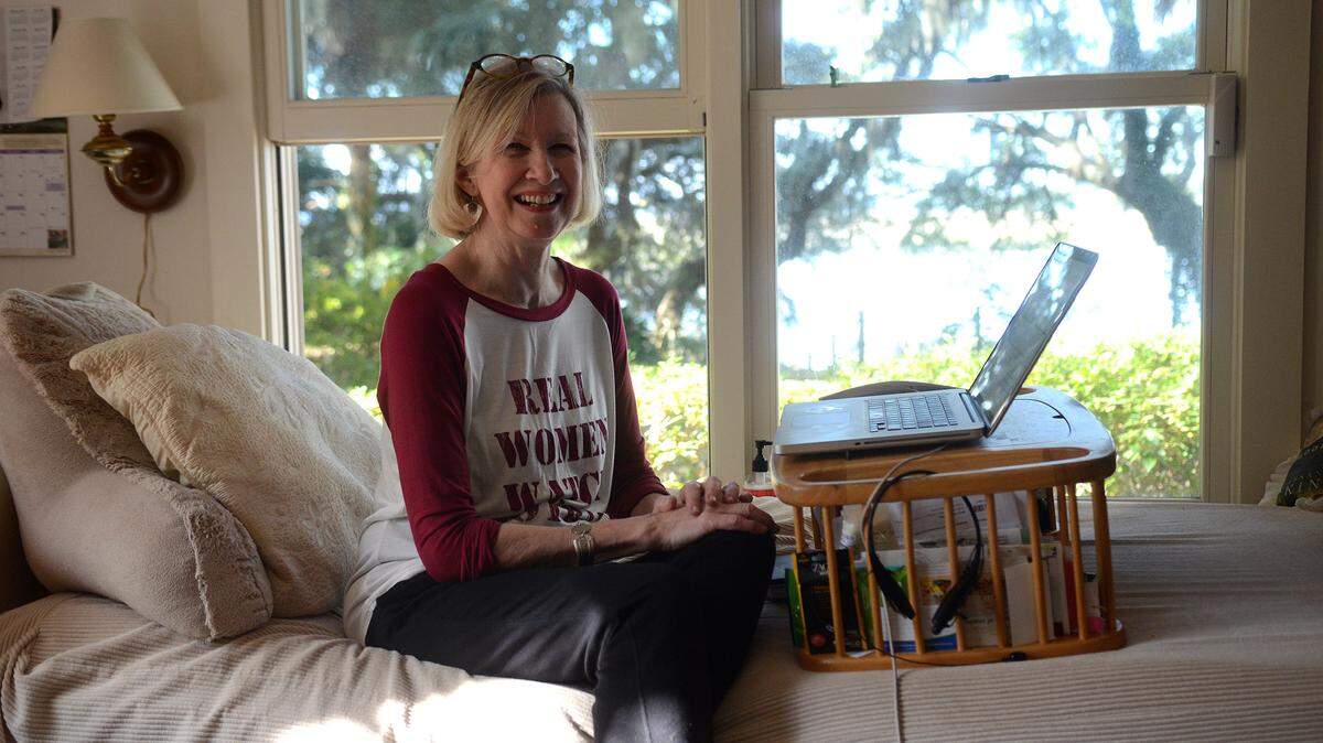 Cassandra King sits for a portrait on the day bed in her writing room on Thursday afternoon at her home in Beaufort.  King enjoys writing from the day bed so that she can look at the marsh from the windows as she works.