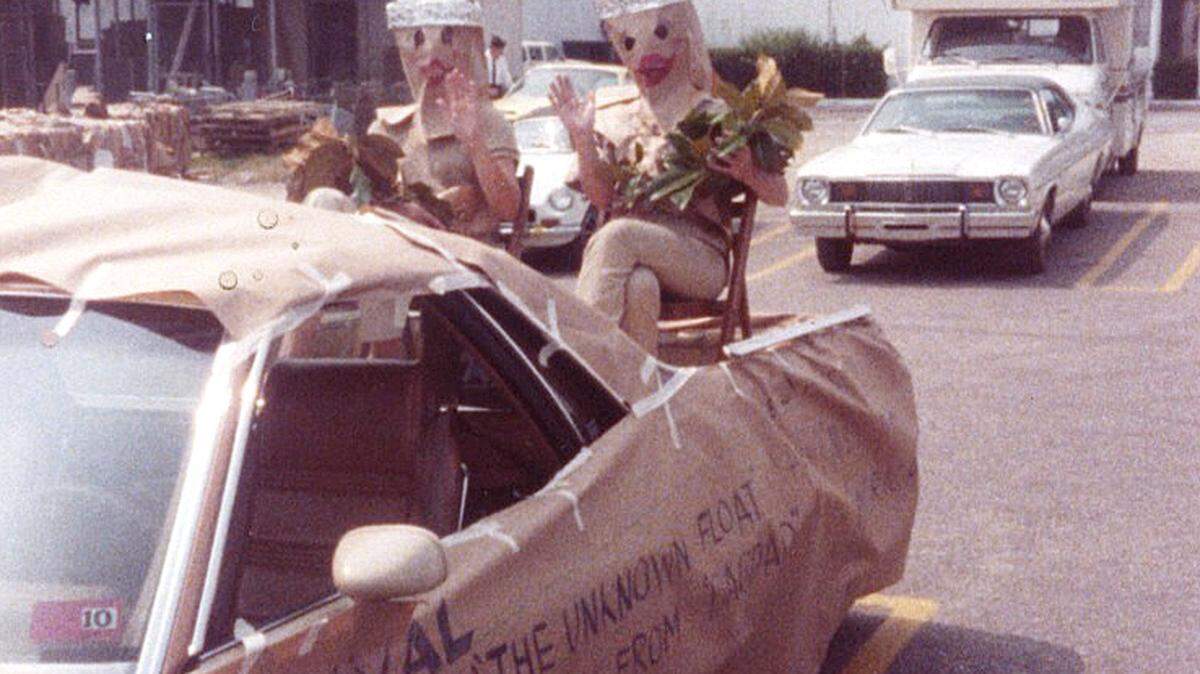 Mary Patrick and Weezie Gibson practice their waves in the Big Star parking lot, as the incognito beauty queens on the "Unknown Float" in the 1983 Beaufort Water Festival Grand Parade.
