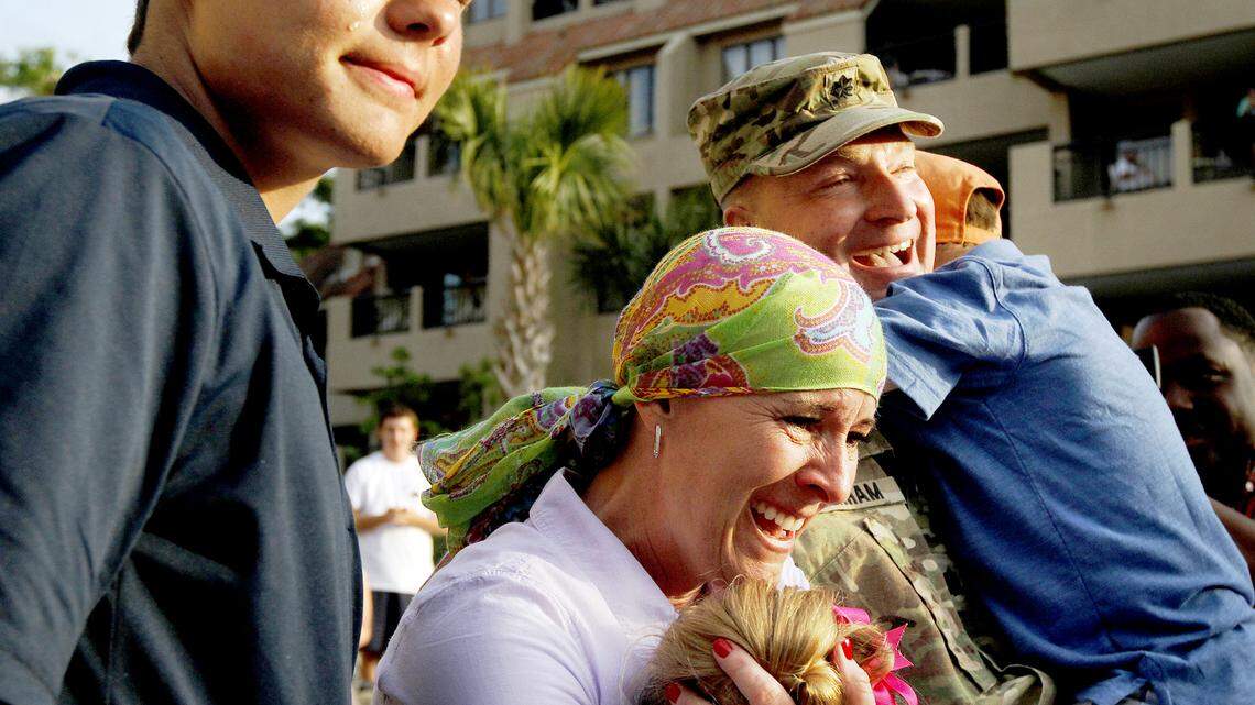 Logan Branham, 17, left, tears up as his father, Lt. Col. Matthew Branham, embraces younger son Preston on Thursday night at Shelter Cove. At center, Traci Branham hugs the couple's daughter Addison. Matthew, of Lehi, Utah, and on leave from a deployment in Afghanistan, surprised the children as they visited Hilton Head with their grandparents.