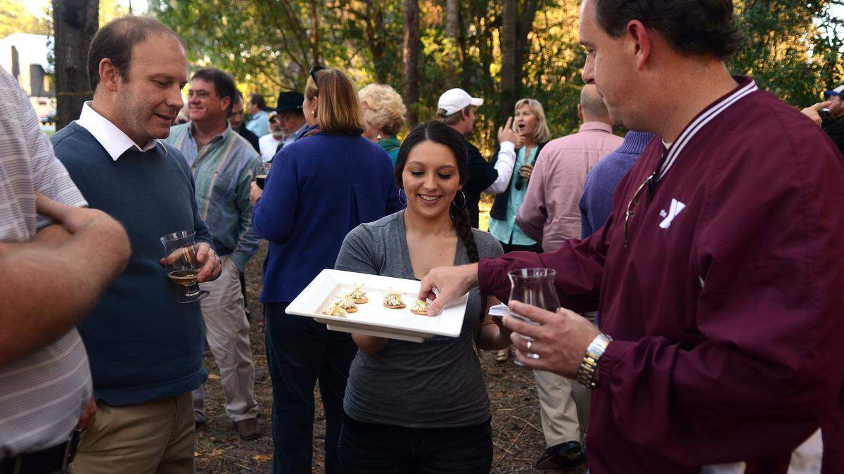 Cassie Bautista, a server at Fat Patties in Beaufort, offers samples to Michael Bostwick, right, and Andy Harper, left, during a gathering the afternoon of Nov. 3, 2014, at the future site of a new Fat Patties restaurant in Old Town Bluffton.