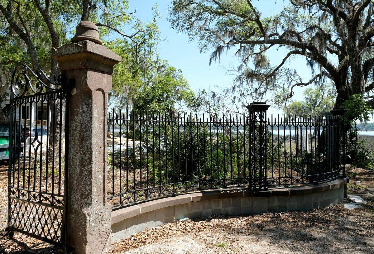 Live oaks with Spanish moss dripping from the branches dapple the light of the front gate to Tidalholm has pot-marked barriers on both sides that hold the iron gate as seen on Thursday morning. Rumor says Union soldiers used the posts as target practice when the home was used as a hospital during the Civil War.