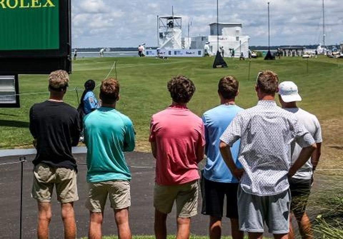 Spectators watch the first day of tournament play of the RBC Heritage from afar of the 18th hole on Thursday, June 18, 2020.