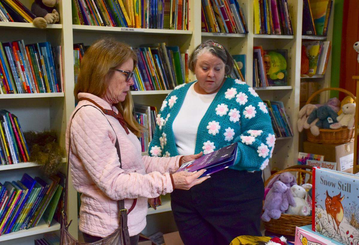 Storybook Shoppe owner Sally Sue Lavinge, right, answers a customer’s question at the Old Town Bluffton children’s bookstore, which is looking for a new location.