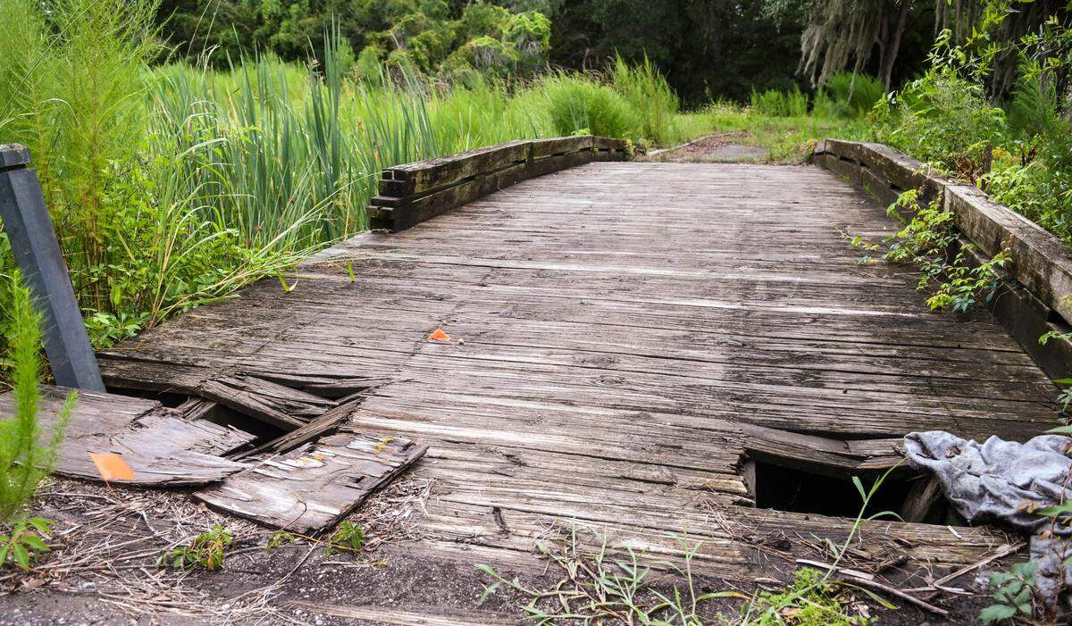 Wooden planks of a golf cart bridge at the former Planters Row Golf Course have rotted away as seen on Monday, Aug. 22, 2022 on Hilton Head Island. The 103-acre property – bounded by U.S. 278, Dillon and Union Cemetery roads – is planned to become a community park. Purchased by the town of Hilton Head in 2013, it was opened for public use in Feb. 2021 after shrubbery and downed-trees were removed.