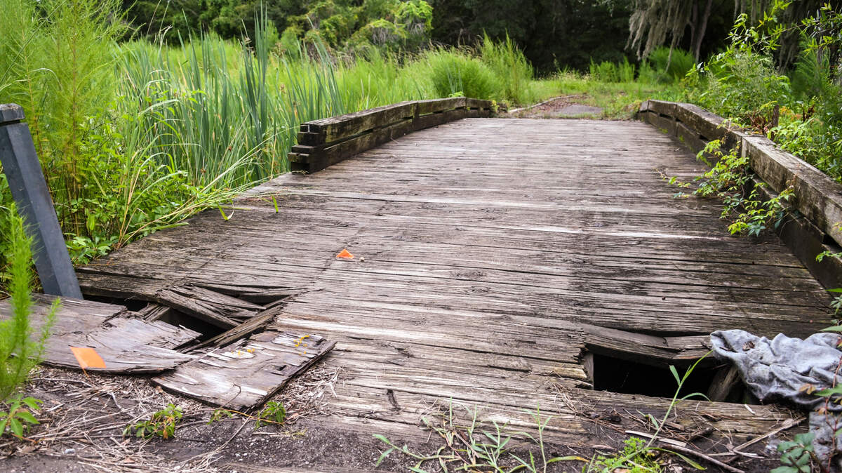 Wooden planks of a golf cart bridge at the former Planters Row Golf Course have rotted away as seen on Monday, Aug. 22, 2022 on Hilton Head Island. The 103-acre property – bounded by U.S. 278, Dillon and Union Cemetery roads – is planned to become a community park. Purchased by the town of Hilton Head in 2013, it was opened for public use in Feb. 2021 after shrubbery and downed-trees were removed.