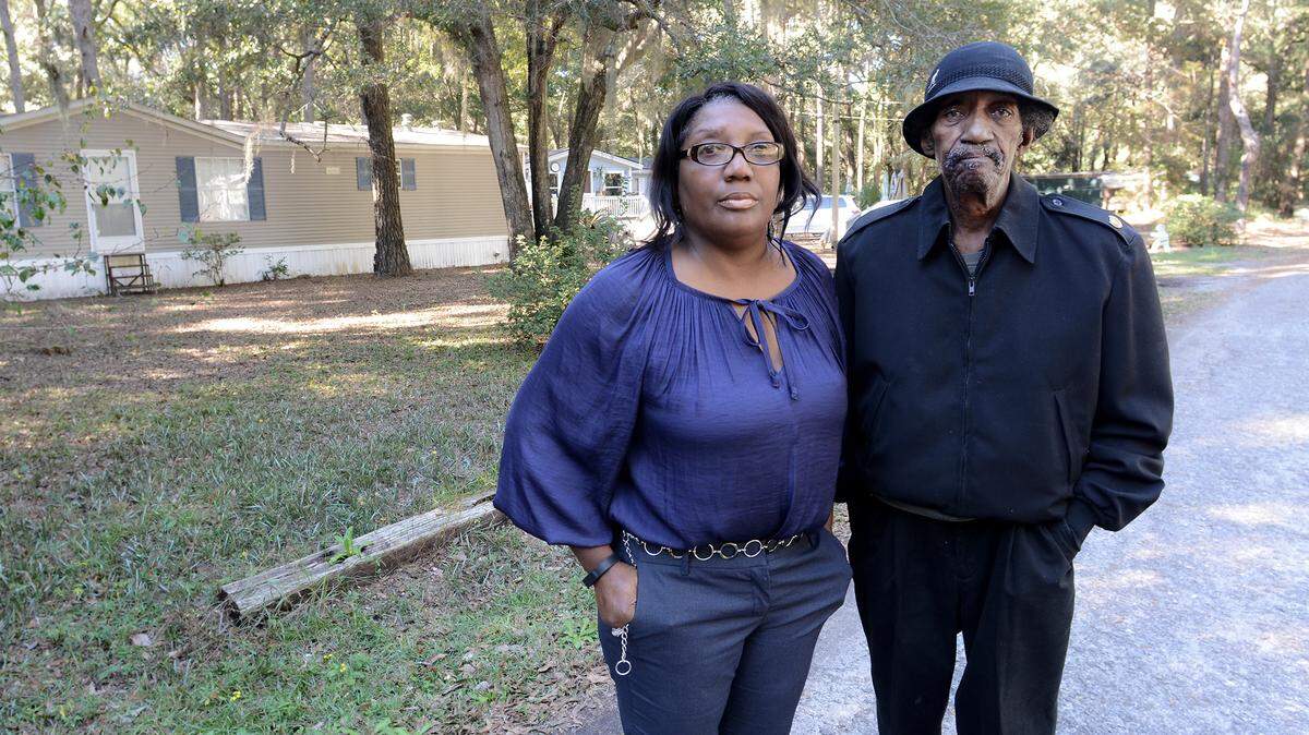 Matthew Allen and his niece, Katrina Coleman, stand on the family property along Allen Road on Hilton Head Island on Friday. The two are among the 75 descendents of the original owner of the 38-acre waterfront tract bought by freed slaves after the Civil War who are trying to stop the sale of their heirs property before a court hearing Monday. They question the methods employed by the lawyer who initiated the lawsuit to sell the property.