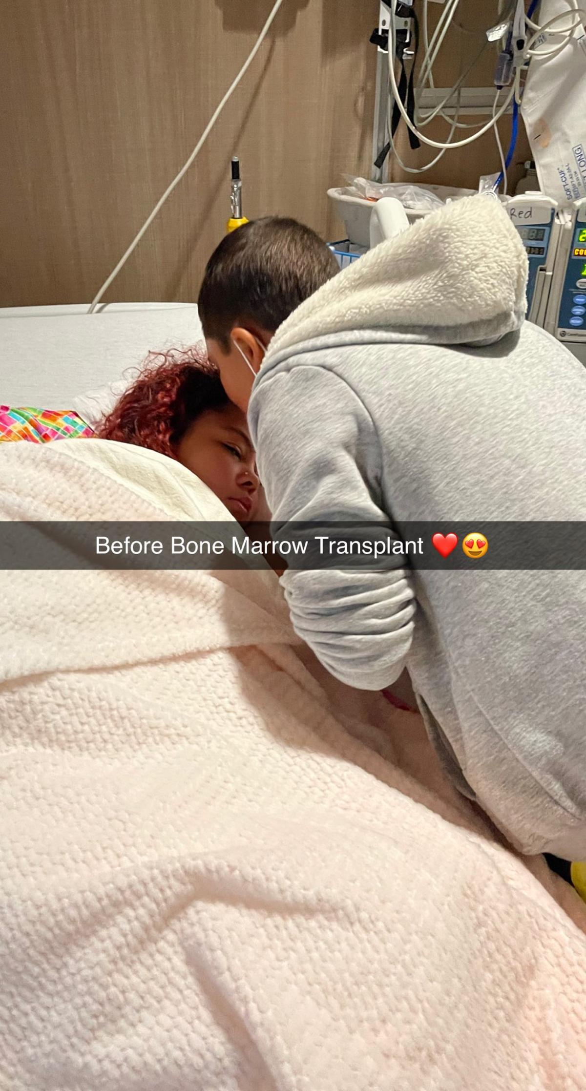 Layton, 9, leans down to kiss his sister Lexi, 16, on the forehead before they both go into surgery for a bone marrow transplant.