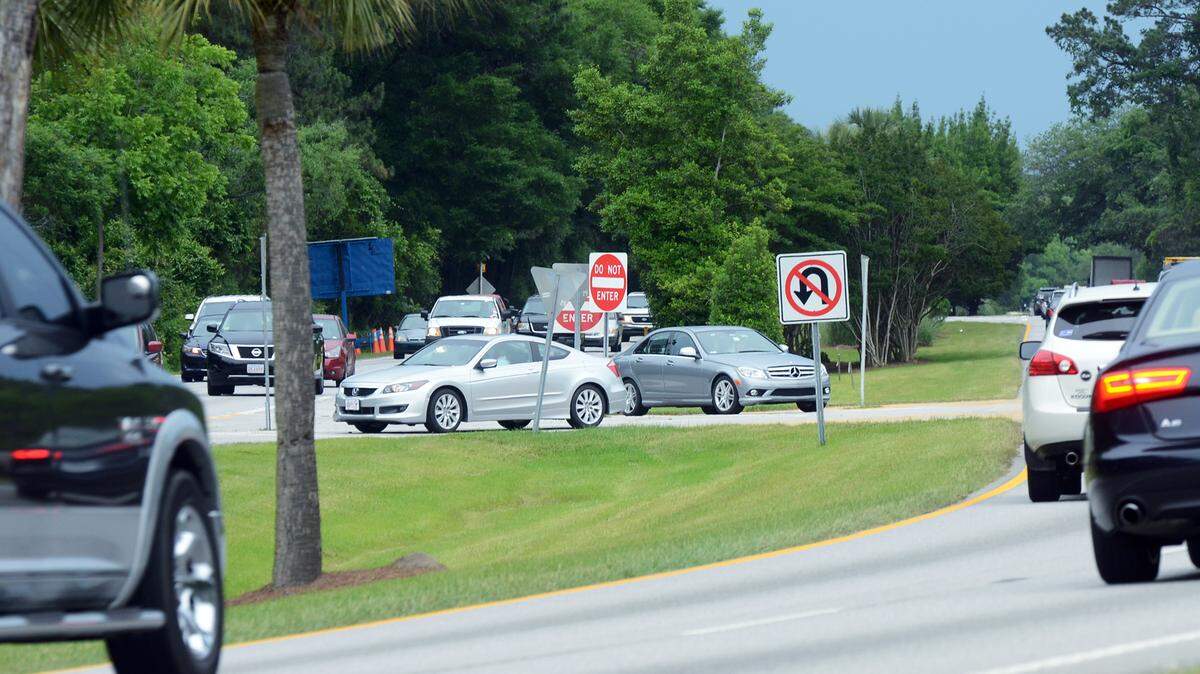 A silver Honda exiting Windmill Harbour into the westbound lanes and a gray Mercedes try to cross the eastbound lanes to enter the development wait in the median of William Hilton Parkway for a break in the traffic on Thursday afternoon. Work should begin in two weeks on a long-awaited traffic project that is expected to make driving into and out of Windmill Harbour a little easier.