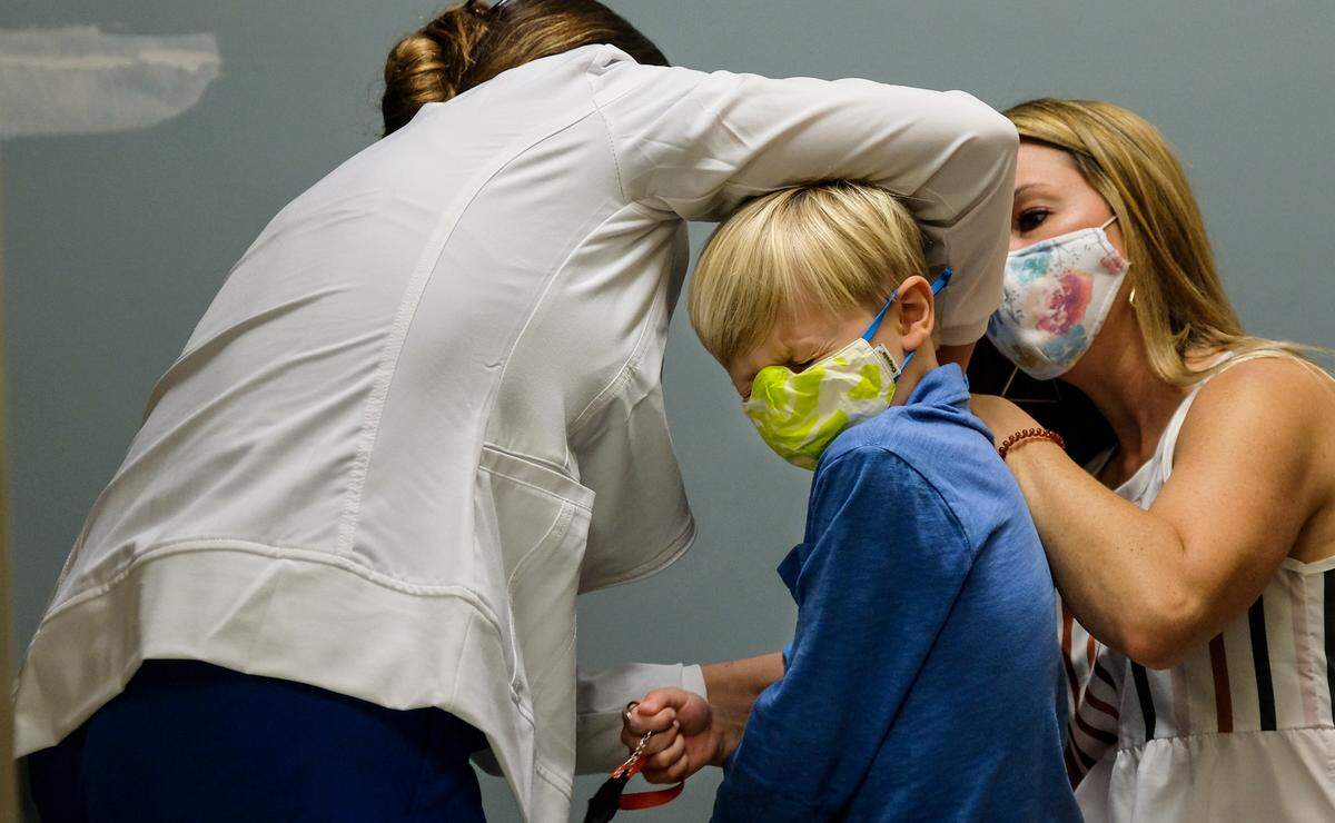 After stressing to his mother, Emily Harris, right, that he was “really nervous” about getting Pfizer-BioNTech’s coronavirus vaccine, Holland Harris, 7, turns his head on Wednesday, Nov. 10, 2021, and grimaces in anticipation as registered nurse Audrey Woodley-Cruz administers the shot at Beaufort Memorial Hospital’s vaccine clinic at the Port Royal Medical Pavilion in the town of Port Royal.
