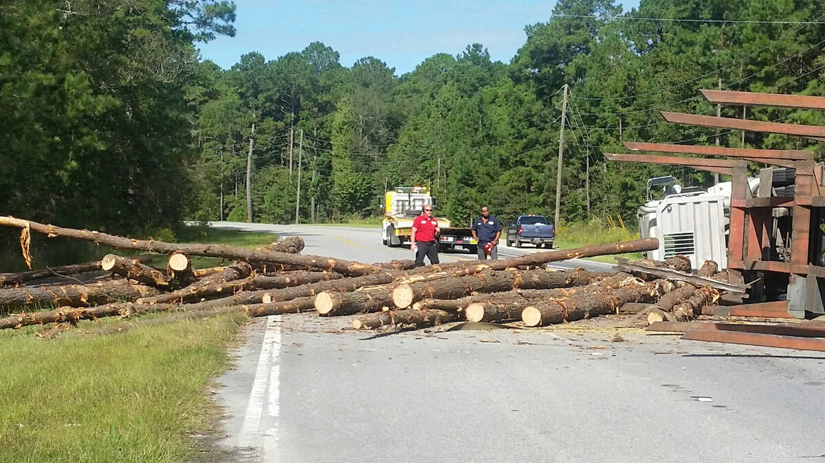 Observers take in the spectacle of logs strewn across Okatie Highway near Freedom Parkway in Jasper County on Oct. 12, 2015.