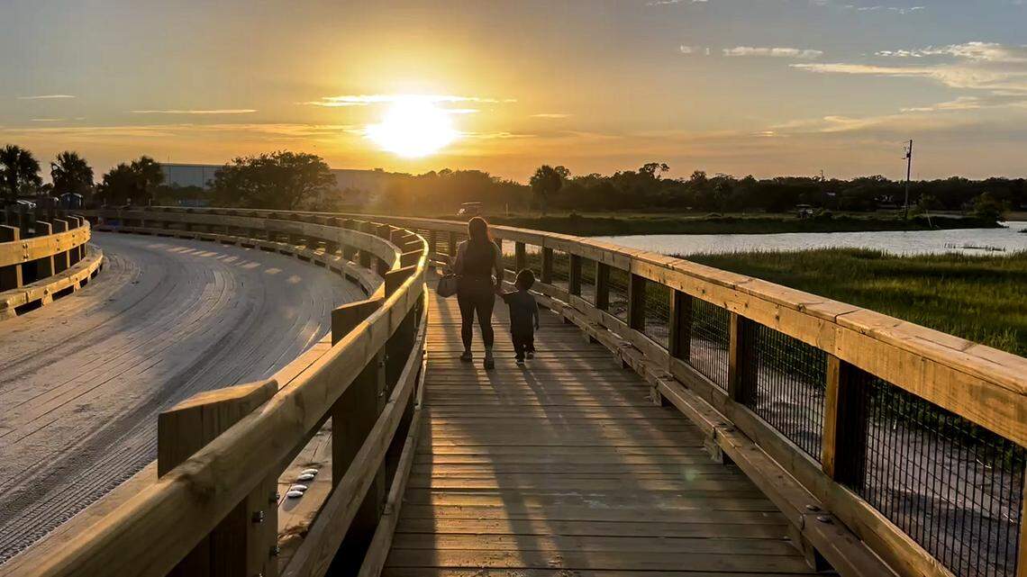 A mom and her young son walk on the pedestrian portion of a new 24-wide wooden bridge between Sands Beach and the main parking area.