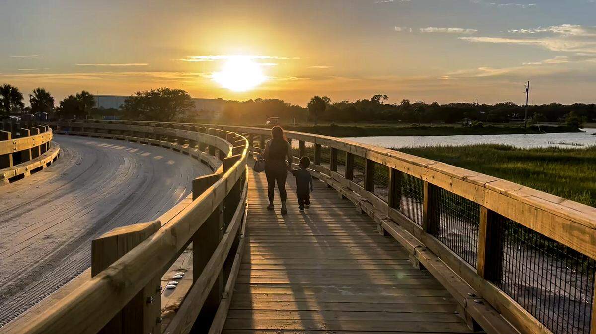 A mom and her young son walk on the pedestrian portion of a new 24-wide wooden bridge between Sands Beach and the main parking area.