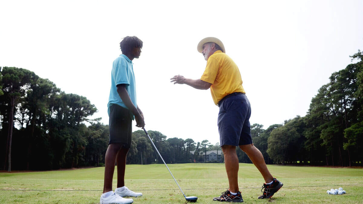 Robert Seignicious receives some instruction from Dave McDonald as Seignicious practices on Friday at Port Royal Golf Club for the upcoming Special Olympics North America Golf Invitational.