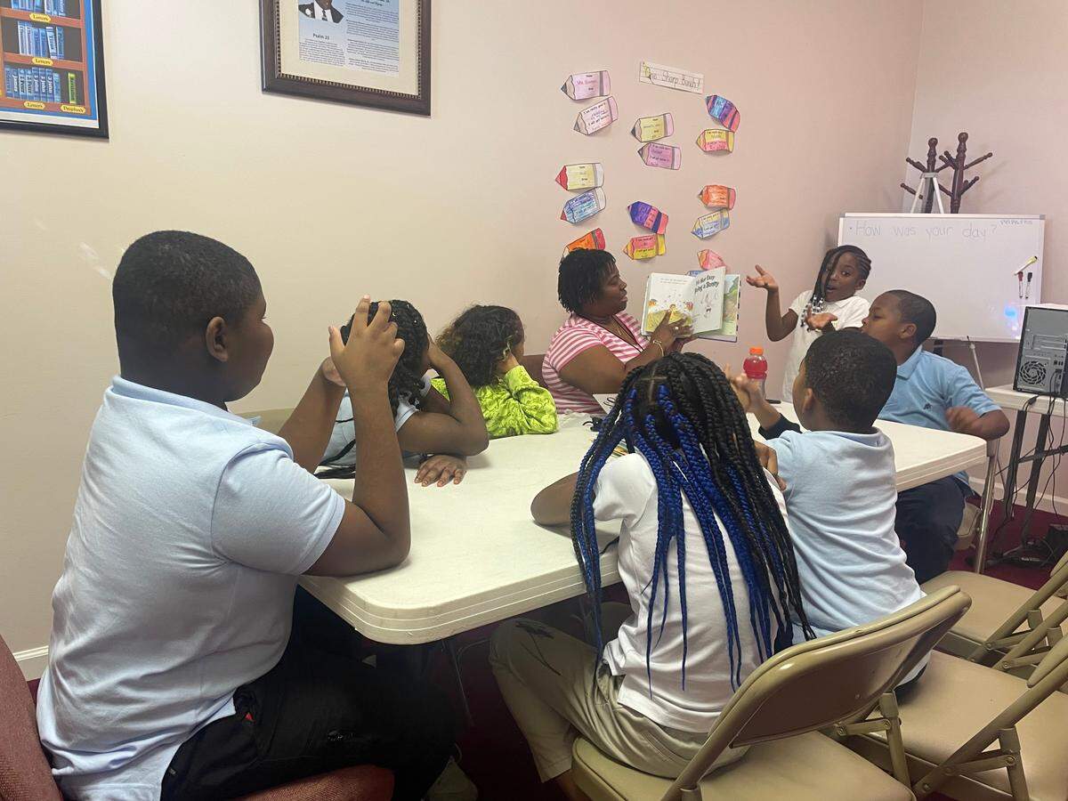 Students at Mt. Carmel Baptist Church read a book together.