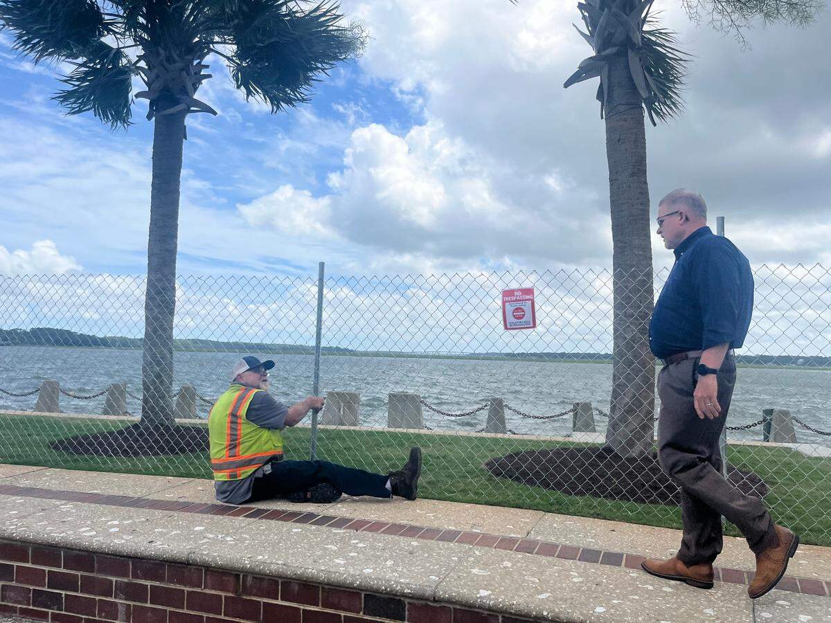 Beaufort City Manager Scott Marshall greets Joe Ciccone of Public Works as he works on a fence that has been erected to keep the public from accessing the promenade along the Beaufort River. “It wasn’t a fun decision,” Marshall said of the move to close the popular promenade.