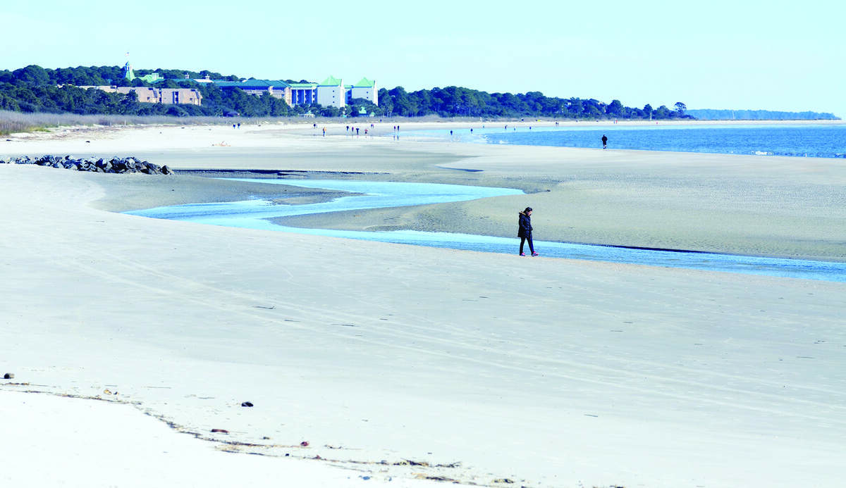A beachgoer strolls along the edge of The Folly on Jan. 20 as it runs south parallel to the shore at Hilton Head Island's Singleton Beach. The tidal creek that emanates from the oceanfront marsh between Singleton Beach Road and Burkes Beach Road has changed course, a natural but dramatic phenomenon.