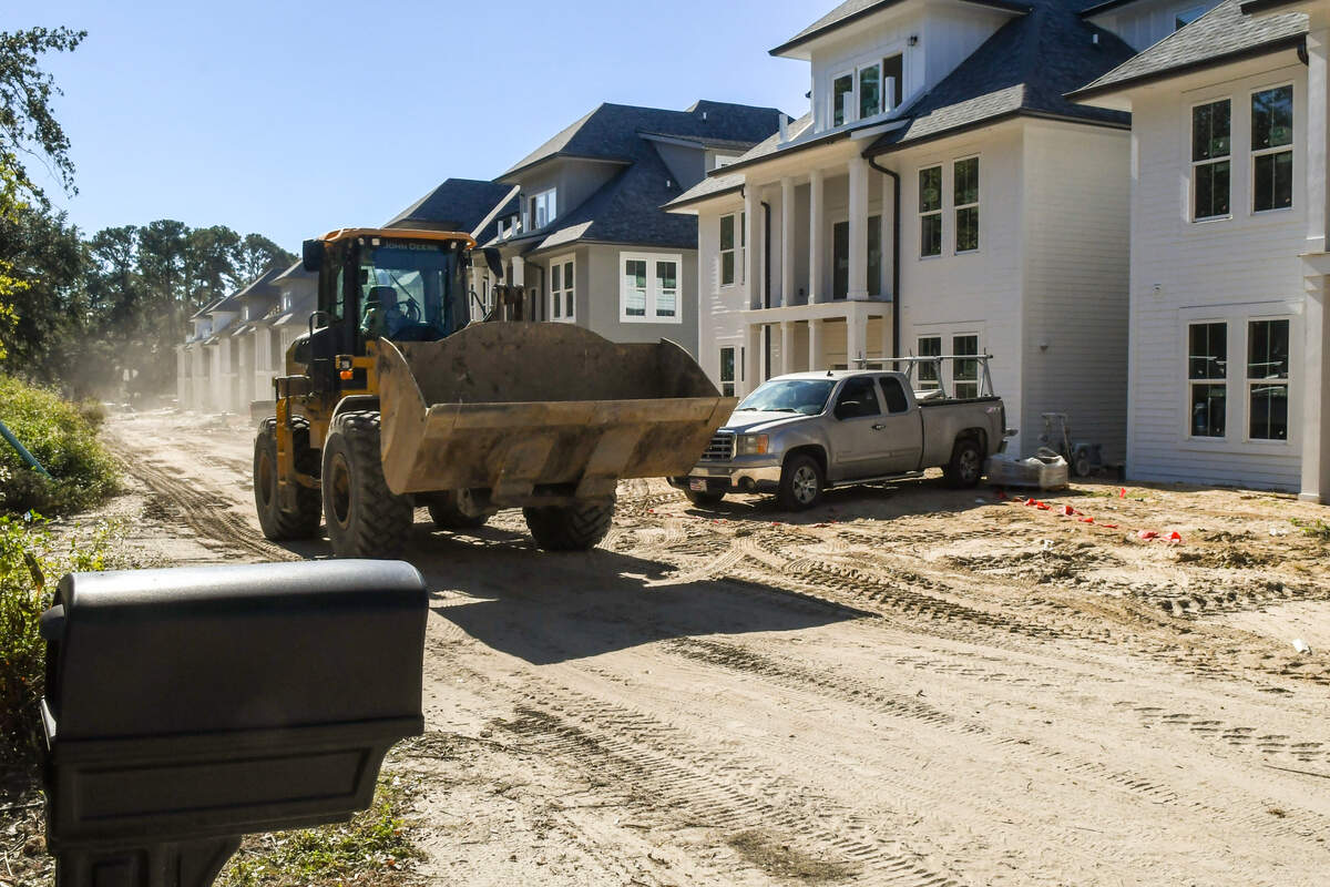 A bulldozer rumbles down the road in front of the Christina and Benji Gecy’s home on Thursday, October. 19, 2023 in the Belleview Bluff subdivision. The 50-foot wide private road known as Roberta Lane is routinely used as part of the construction of Integra Wharf at Battery Creek as it constructs 12, three-story apartment buildings.