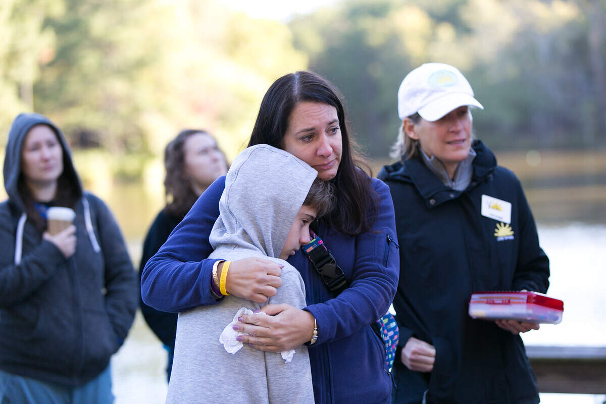 Jessica Mugrage, Michael Mugrage’s mother, holds on to her younger son Matthew, who is 12 years old.