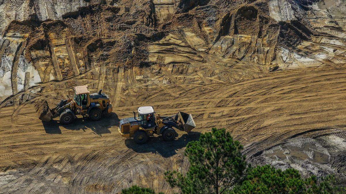 Two front-end loaders pass by each other, one carrying a load of dirt, as work continues on building the infrastructure for the new residential development as seen on Oct. 24, 2025, on upper Cane Island in Beaufort County.  