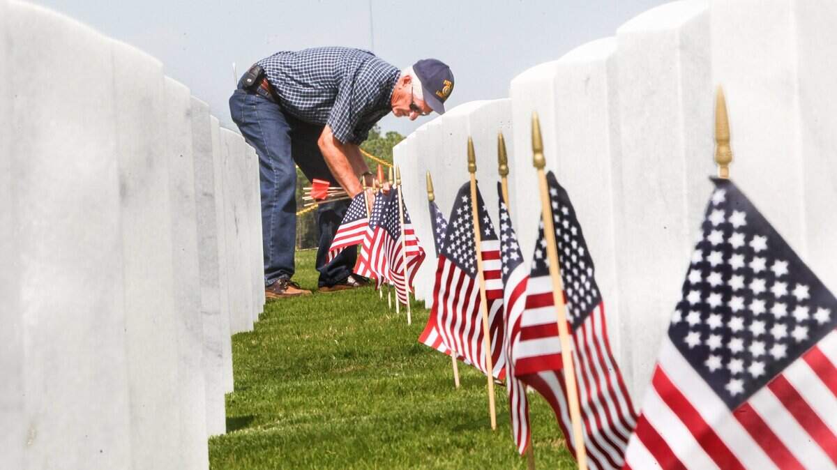 Volunteers prepared Fort Jackson National Cemetery for a Memorial Day observance by placing American flags on nearly 2,800 headstones at the cemetery in this file photo.