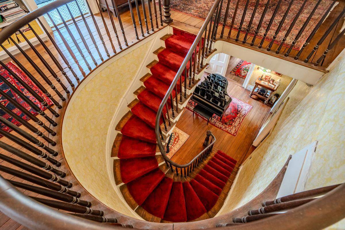 The home welcomes visitors into a grand entrance hall, where a floating staircase immediately draws the eye.