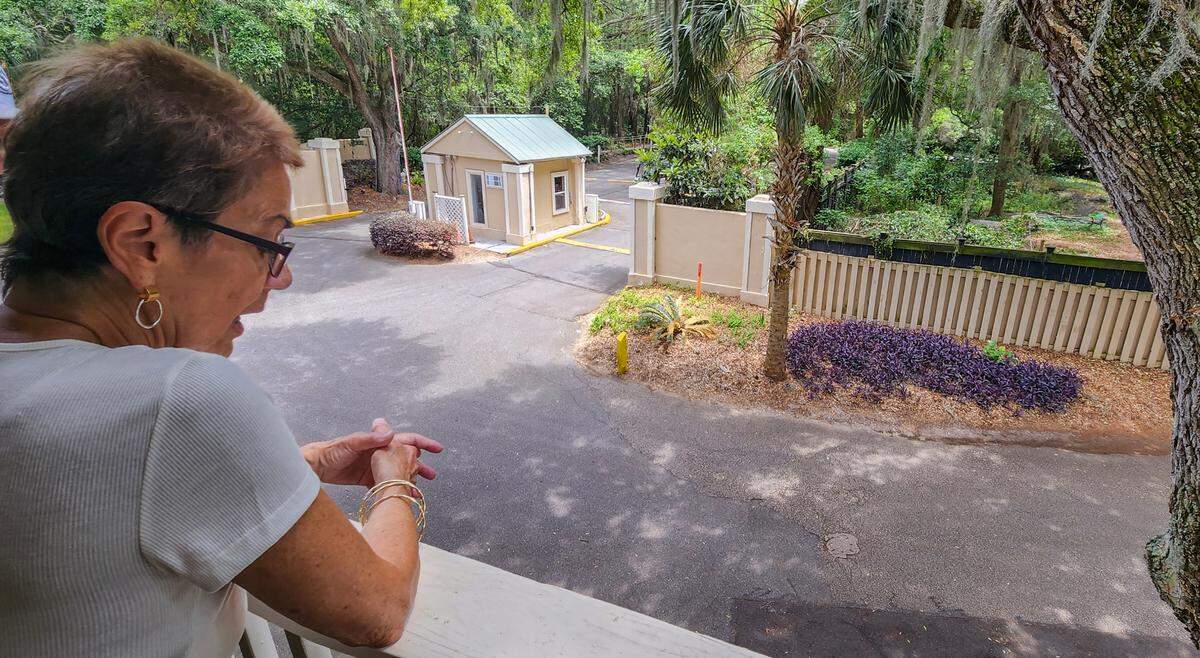 Terri Coco, looks from the balcony of her home at The Spa on Port Royal Sound, that shows the fences that separate the community from the ‘cat sanctuary’ on May 9, 2023 on Hilton Head Island. Coco says on numerous occasions she has found cat feces at her door and believes the feral cats are the culprits.