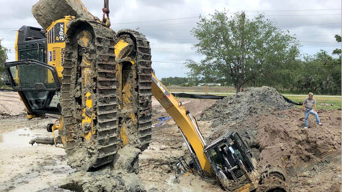 A bulldozer is lifted free from the mud at the site of a pond project at Meadowbrook Baptist Church on Lady's Island on Saturday, May 26, 2018. A county-owned excavator, also pictured, was stuck trying to free the bulldozer Friday night.