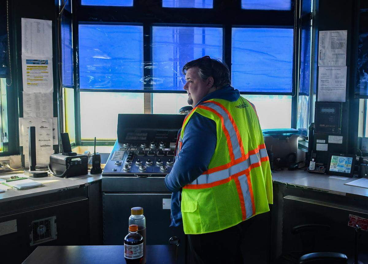 Bridge Captain Nathan Atkinson-McClellan turns to resume a conversation after receiving a phone call request to open the swing span of the Richard V. Woods Memorial Bridge to allow a sailboat to continue its journey using the Intracoastal Waterway on Nov. 29, 2022 in the Beaufort River.