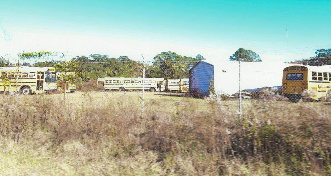 School buses in various states of repair are located in a fenced-in area where Isaiah Gadson Jr. lived in the 1980s off of Glaze Drive and and Ramsey Road in Beaufort.