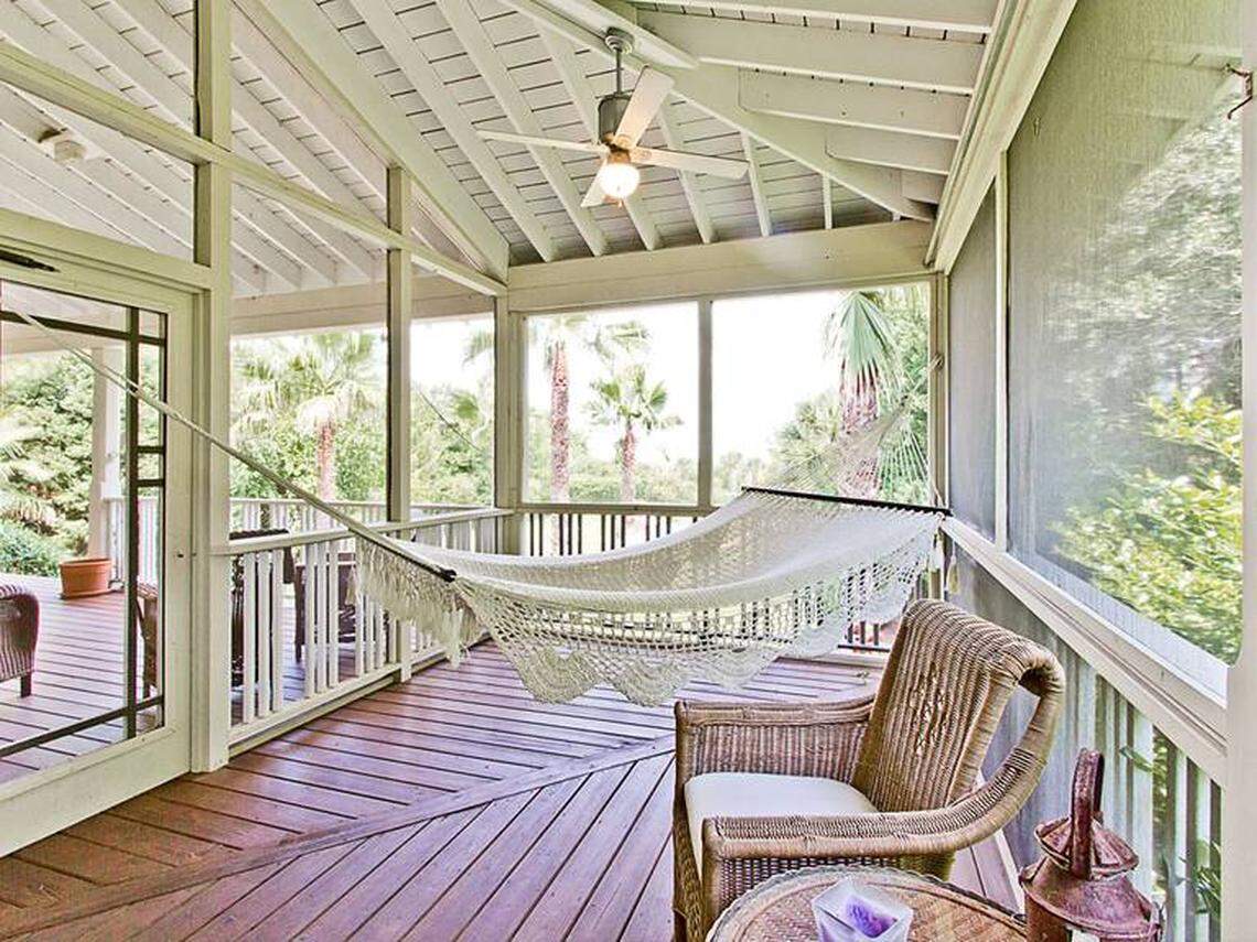 The home features broad screened porches and beach views.