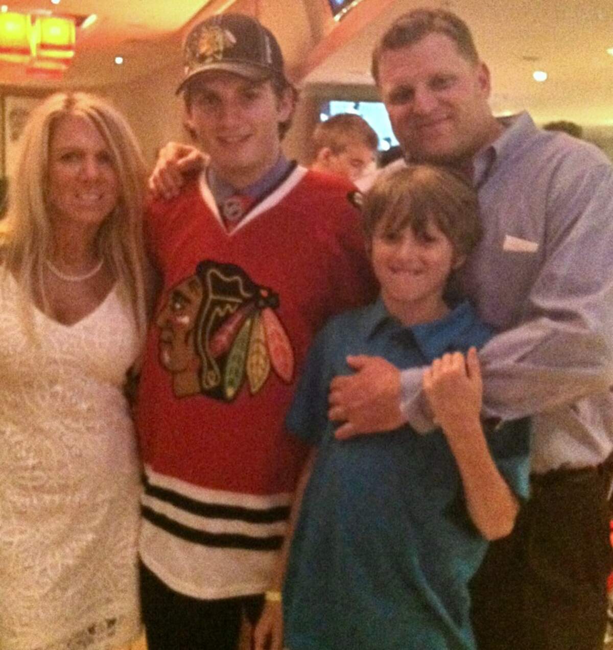 Ryan Hartman in a real Chicago Blackhawks jersey when the favorite NHL team of his childhood drafted him in the first round in 2013. With him are his mother, Kim, brother, Tanner, and father, Craig Hartman.