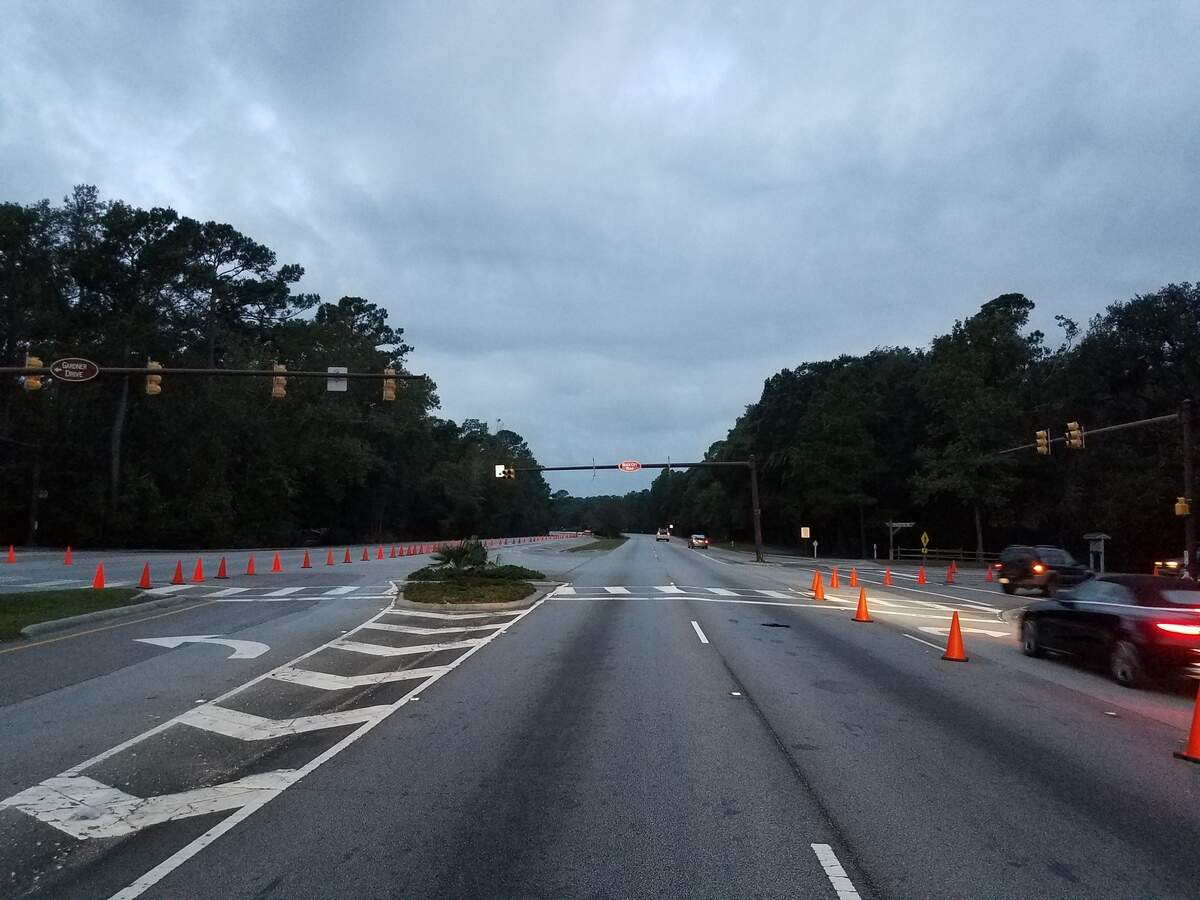 A traffic light pole (center) was damaged in a crash early Tuesday morning. Crews are working to fix it as the driver of the car who hit it is in the hospital with minor injuries.