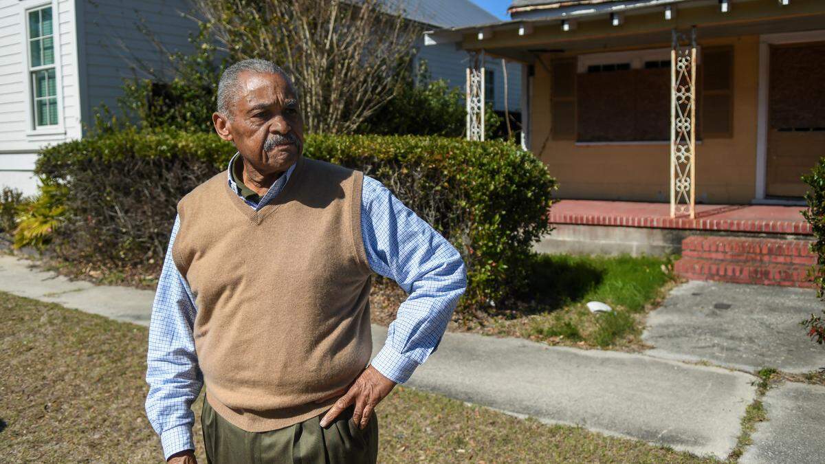 Kenneth Singleton Sr. stands in front of one of two neighboring houses that he owns on Duke Street on Thursday, Feb. 15, 2024 in downtown Beaufort. While both structures may contribute to Beaufort’s historic district, Singleton received permission on Wednesday from Beaufort’s Historic Review Board to demolish both.