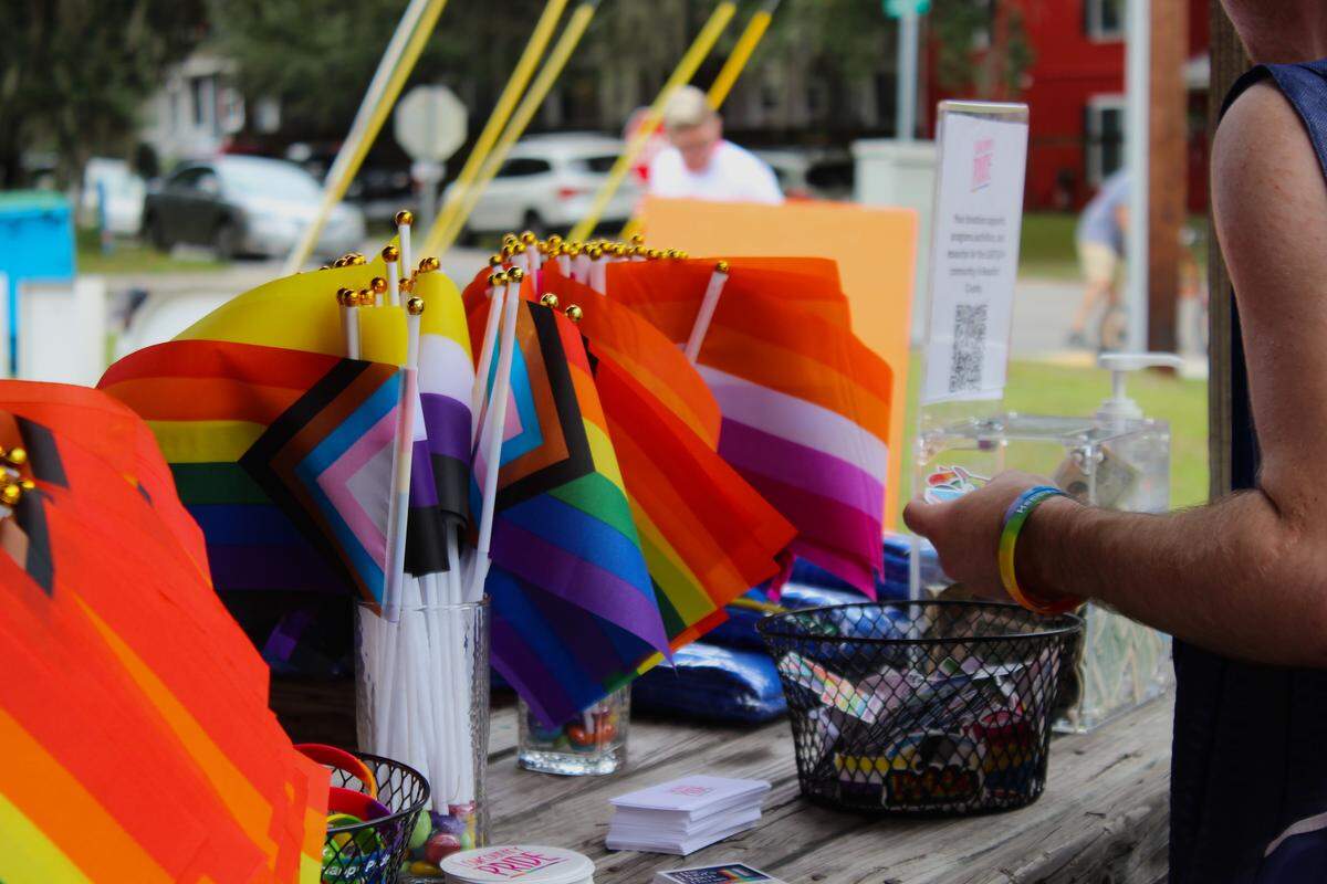 An eventgoer looks through a basket of free stickers at Lowcountry Pride’s 2025 celebration, held in Live Oaks Park in Port Royal.