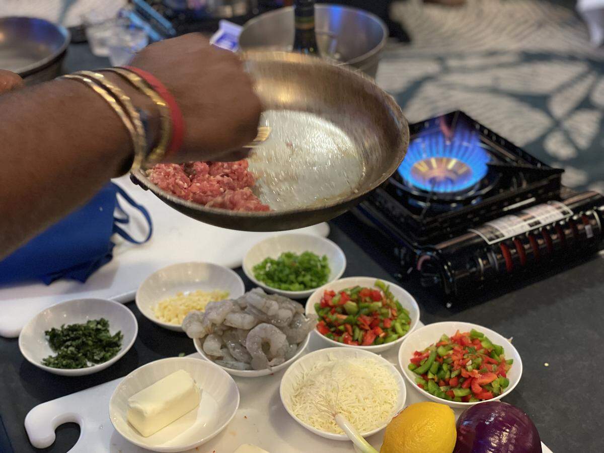 Charleston Rep. JA Moore (D) sautees a pan of italian sausage over an open flame. The topic of gun control is personal for Moore, whose half-sister was killed in the 2015 Charleston church shooting.