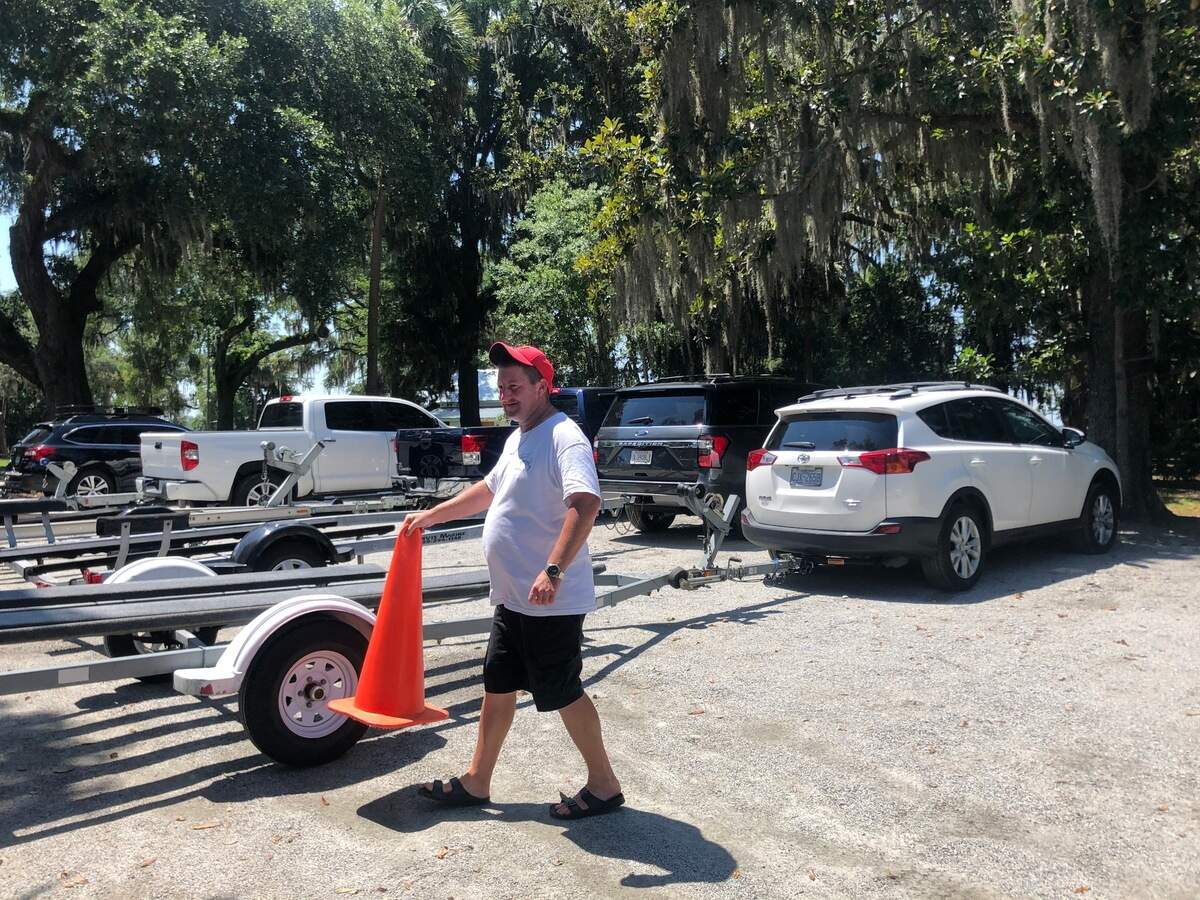 Jeffrey Gainey moves a cone so a driver hauling a boat trailer can back into a parking space. Gainey volunteers to direct traffic at the boat landing all weekend from 7 a.m. until sundown.