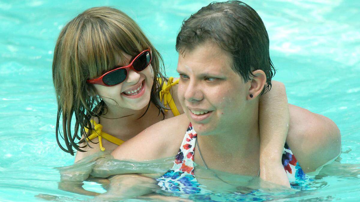 Camp Leo participant and Bluffton resident Annabell Granger, 6, rides on the shoulders of counselor Callie Fralix, a former camper, during a Wednesday outing to the Greenwood Forest pool in Sea Pines on Hilton Head Island. Annabell, who suffers from a retinal disease called cone-rod dystrophy, is one of 25 sight-impaired children who attended last week's camp.