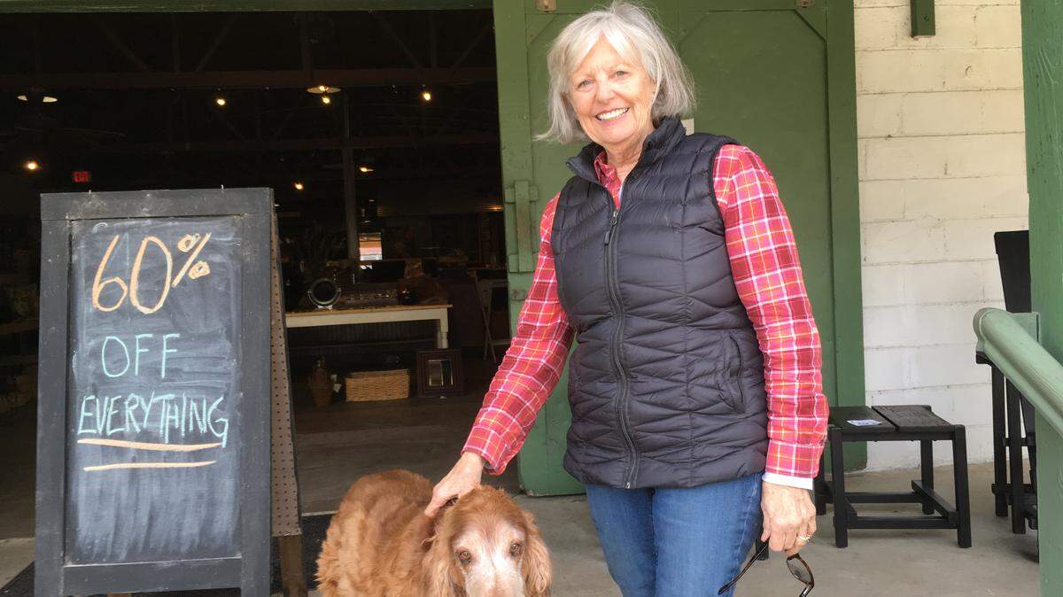 Rindy Jerue stands with her Irish Setter, Blue, on the porch of Lowcountry Store she has owned more than 10 years on St. Helena Island. The store is closing Saturday.