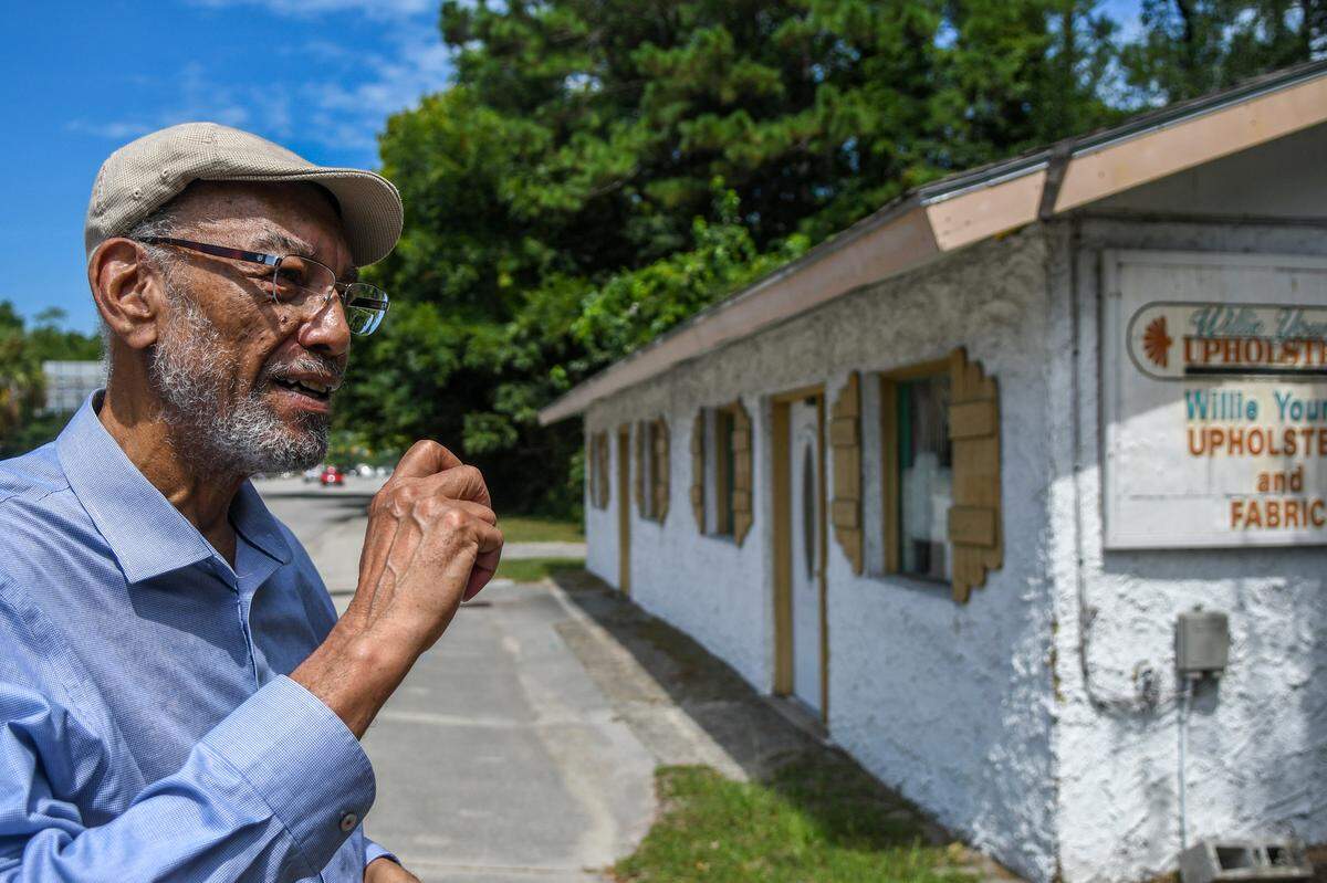 Standing along U.S. 278, Robert Patterson talks on July 16, 2024, about the store his father opened in 1954 on Hilton Head Island. Now housing Willie Young’s Upholstery and Fabric, the original concrete-block building closest to the camera was half the size, ending where the two side-by-side windows meet. “This is the oldest, continuous operating business on Hilton Head Island” Patterson said while talking about his family’s property.