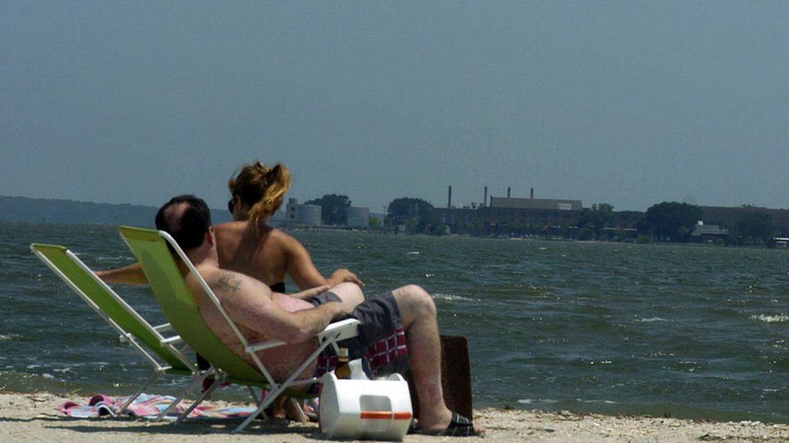 An open beers sits in a cooler next to a couple enjoying a hot Thursday afternoon at Sands Beach in Port Royal.